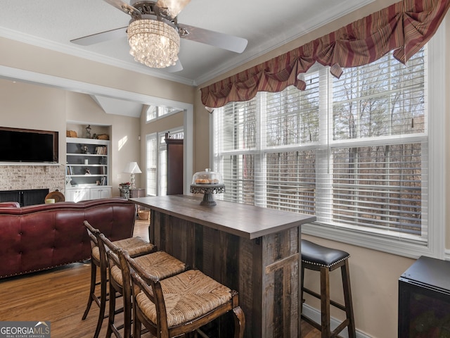 355 Parker Rd, Covington, GA 30014 - dining space featuring ceiling fan, wood finished floors, lofted ceiling, crown molding, and built in shelves