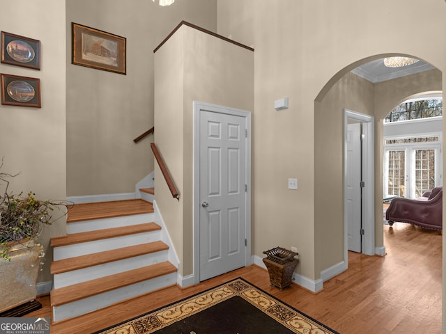 355 Parker Rd, Covington, GA 30014 - entrance foyer featuring arched walkways, wood finished floors, ornamental molding, a towering ceiling, and stairs