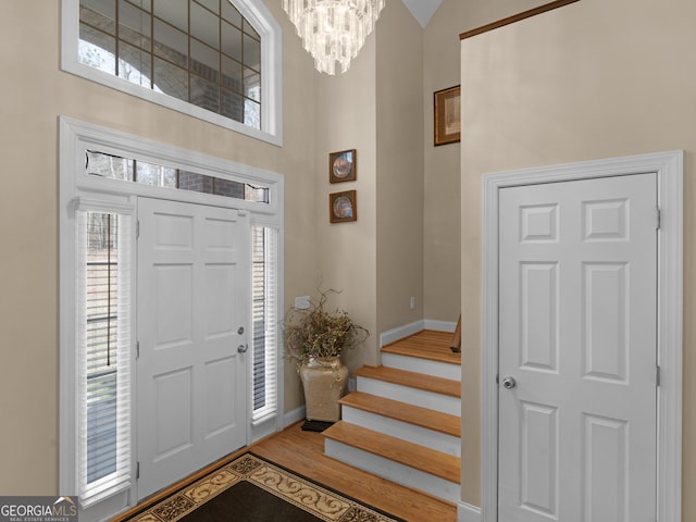 355 Parker Rd, Covington, GA 30014 - foyer entrance featuring a chandelier, wood finished floors, stairs, and a towering ceiling