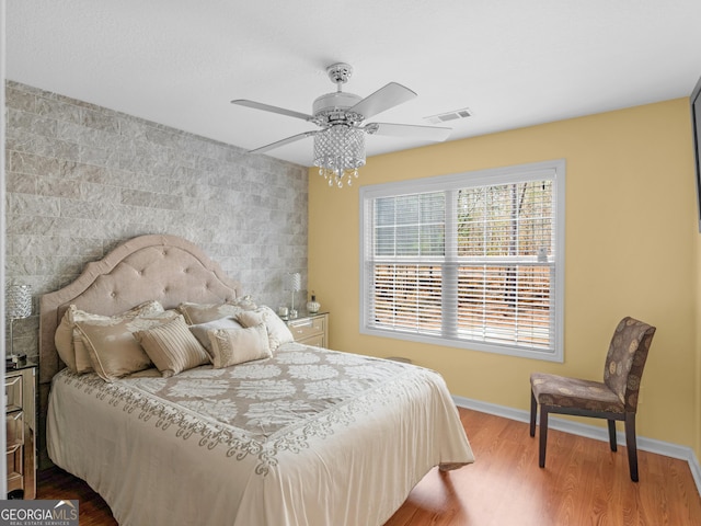 355 Parker Rd, Covington, GA 30014 - bedroom featuring wood finished floors, an accent wall, and a ceiling fan
