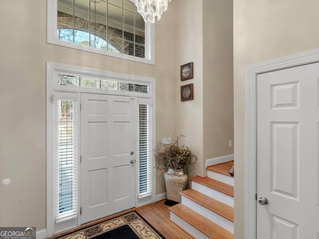 355 Parker Rd, Covington, GA 30014 - foyer with a chandelier, a high ceiling, light wood-type flooring, and stairway