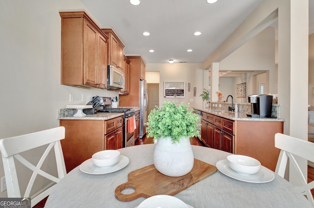 149 Horizon Hl, Newnan, GA 30265 - kitchen featuring appliances with stainless steel finishes, a sink, recessed lighting, light stone countertops, and brown cabinets