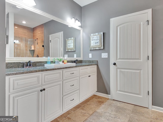 149 Horizon Hl, Newnan, GA 30265 - bathroom with double vanity, tiled shower, baseboards, and stone finish floors