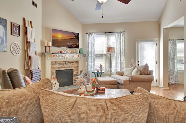 149 Horizon Hl, Newnan, GA 30265 - living room featuring a ceiling fan, wood finished floors, a stone fireplace, vaulted ceiling, and baseboards