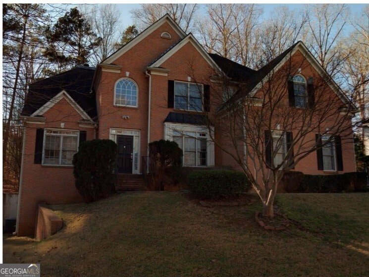 7071 Glen Cove Ln, Stone Mountain, GA 30087 - traditional-style home with brick siding and a front lawn