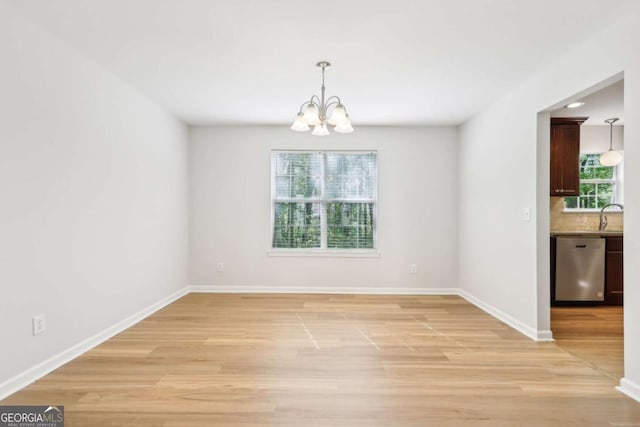 6230 Lillie Ln, Cumming, GA 30040 - unfurnished dining area featuring a chandelier, light wood-type flooring, baseboards, and a sink