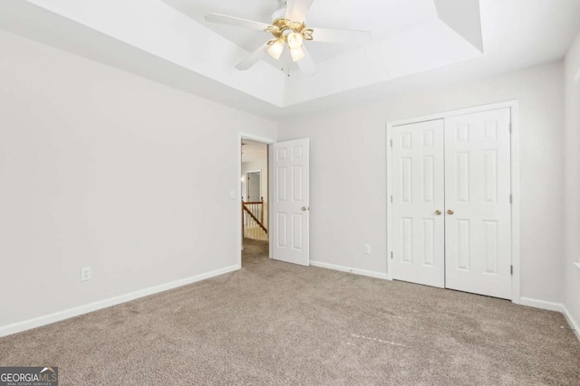 6230 Lillie Ln, Cumming, GA 30040 - unfurnished bedroom featuring carpet flooring, a raised ceiling, baseboards, a closet, and ceiling fan
