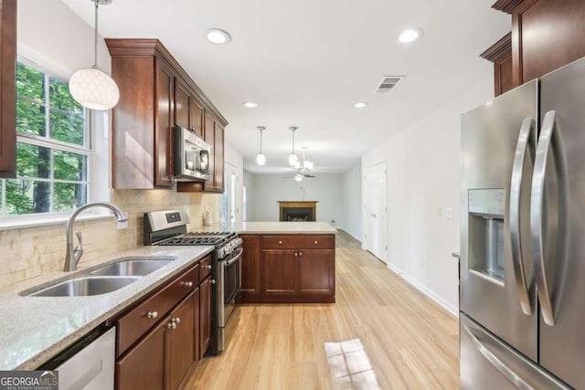 6230 Lillie Ln, Cumming, GA 30040 - kitchen with stainless steel appliances, a sink, light wood-type flooring, healthy amount of natural light, and recessed lighting