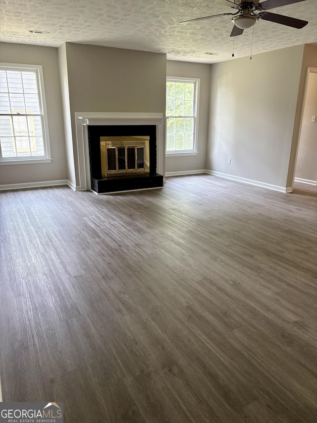 6103 Chaseland Rd, Rex, GA 30273 - unfurnished living room with ceiling fan, wood finished floors, baseboards, a glass covered fireplace, and a textured ceiling