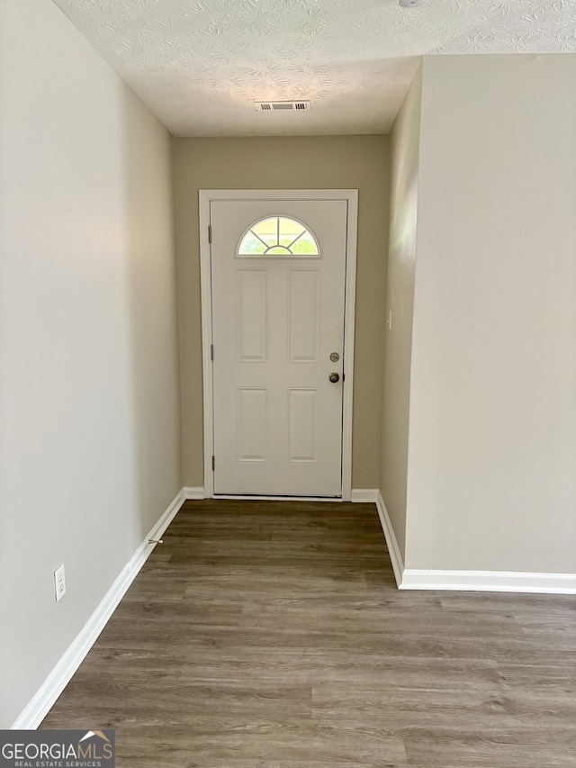 6103 Chaseland Rd, Rex, GA 30273 - doorway to outside with a textured ceiling, wood finished floors, and baseboards
