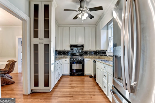 570 Southview Dr, Athens, GA 30605 - kitchen featuring appliances with stainless steel finishes, ornamental molding, white cabinets, a sink, and tasteful backsplash