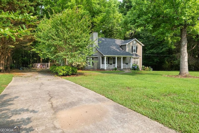 135 Dunwick Ln, Mcdonough, GA 30253 - view of front of house with covered porch, a front lawn, a chimney, roof with shingles, and driveway