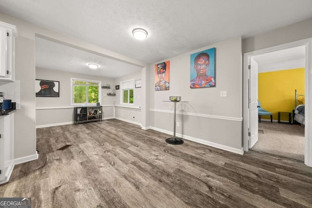 135 Dunwick Ln, Mcdonough, GA 30253 - living area featuring wood finished floors, baseboards, and a textured ceiling