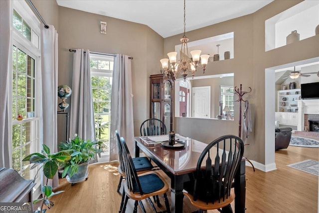 11 Crossbridge Ct, Cartersville, GA 30120 - dining room featuring light wood-style floors, a chandelier, a brick fireplace, and baseboards