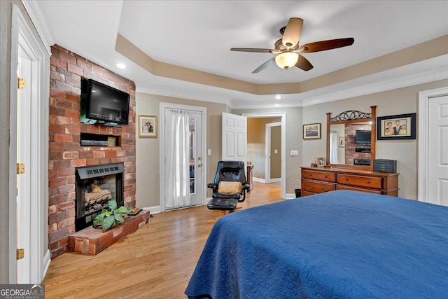 11 Crossbridge Ct, Cartersville, GA 30120 - bedroom with a brick fireplace, light wood-type flooring, baseboards, ornamental molding, and a tray ceiling