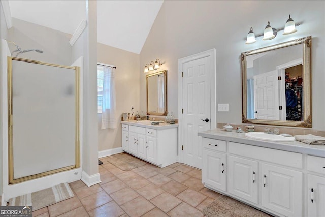 11 Crossbridge Ct, Cartersville, GA 30120 - bathroom featuring a stall shower, vaulted ceiling, two vanities, a walk in closet, and baseboards