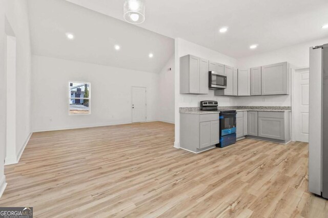 30 Moore Ave, Toccoa, GA 30577 - kitchen with electric range, stainless steel microwave, gray cabinets, light wood-type flooring, and open floor plan