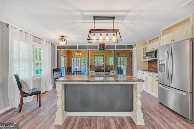 113 Fletcher Rd, Eatonton, GA 31024 - kitchen with appliances with stainless steel finishes, a sink, dark countertops, cream cabinetry, and an island with sink
