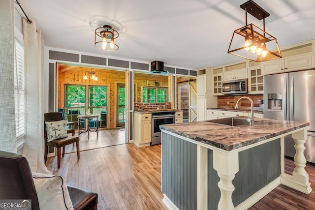 113 Fletcher Rd, Eatonton, GA 31024 - kitchen featuring appliances with stainless steel finishes, a chandelier, a sink, light wood finished floors, and wood walls