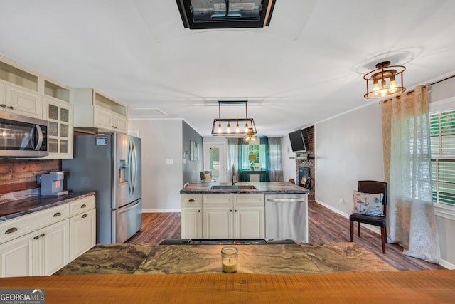 113 Fletcher Rd, Eatonton, GA 31024 - kitchen featuring stainless steel appliances, dark wood-type flooring, glass insert cabinets, and a fireplace