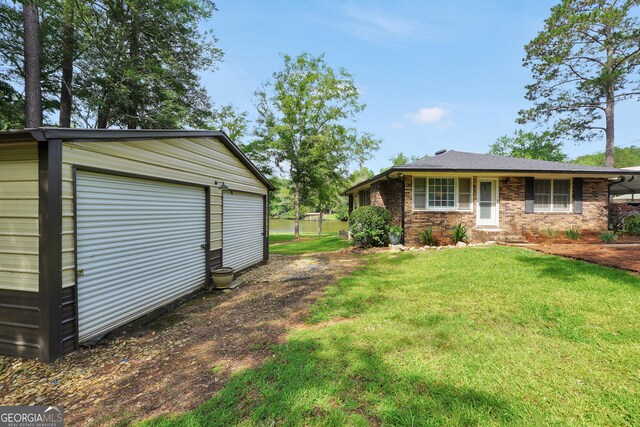 113 Fletcher Rd, Eatonton, GA 31024 - view of green lawn featuring an outdoor structure and a garage