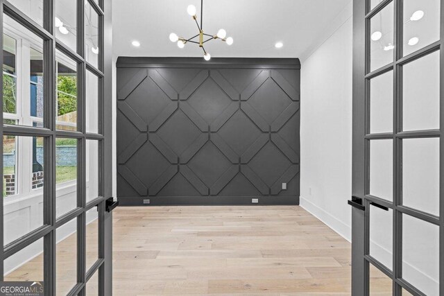 1387 Mineral Springs Rd, Hoschton, GA 30548 - empty room with a chandelier, a decorative wall, baseboards, light wood-style floors, and recessed lighting