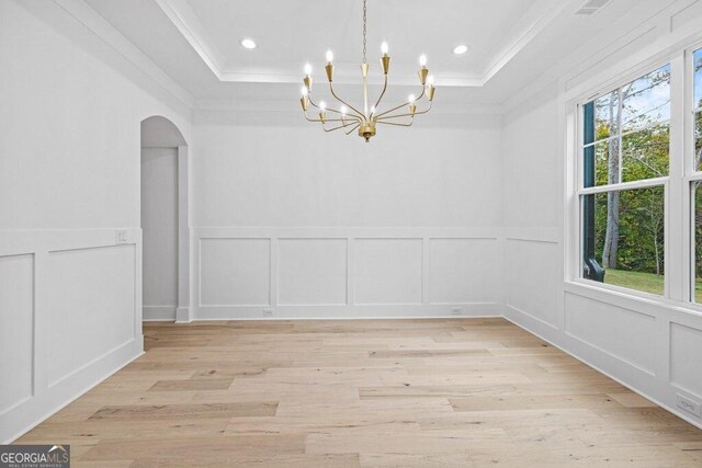 1387 Mineral Springs Rd, Hoschton, GA 30548 - spare room featuring a decorative wall, ornamental molding, a raised ceiling, a chandelier, and arched walkways