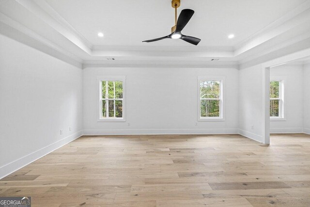 1387 Mineral Springs Rd, Hoschton, GA 30548 - spare room featuring a tray ceiling, crown molding, ceiling fan, light wood-style floors, and baseboards
