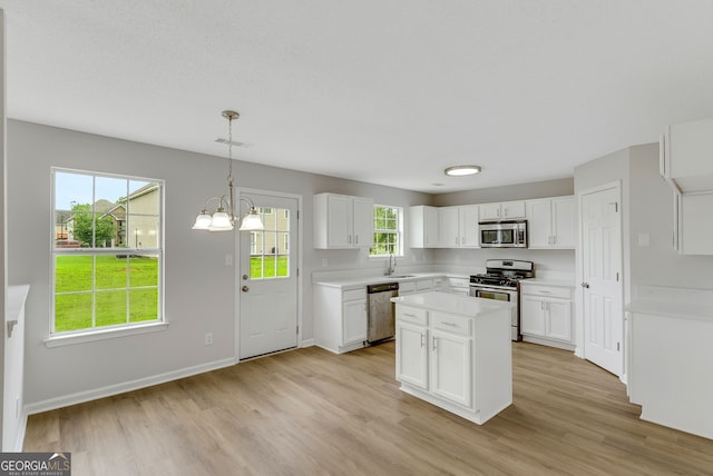 907 Brisley Cir, Hampton, GA 30228 - kitchen with appliances with stainless steel finishes, light wood finished floors, white cabinets, light countertops, and a chandelier