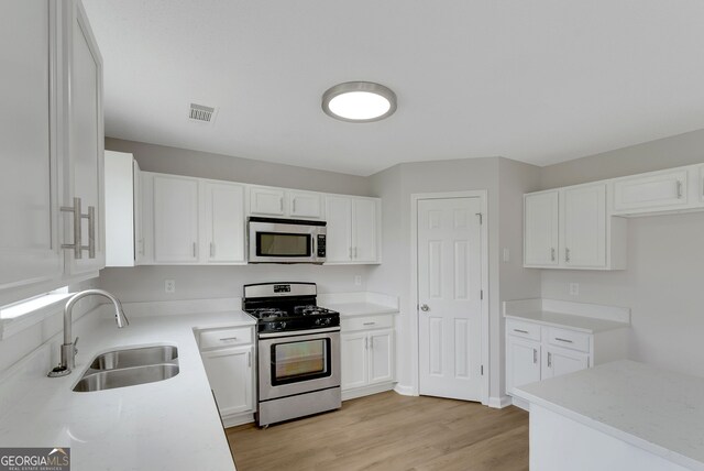 907 Brisley Cir, Hampton, GA 30228 - kitchen featuring stainless steel appliances, white cabinets, light wood-style floors, and light countertops