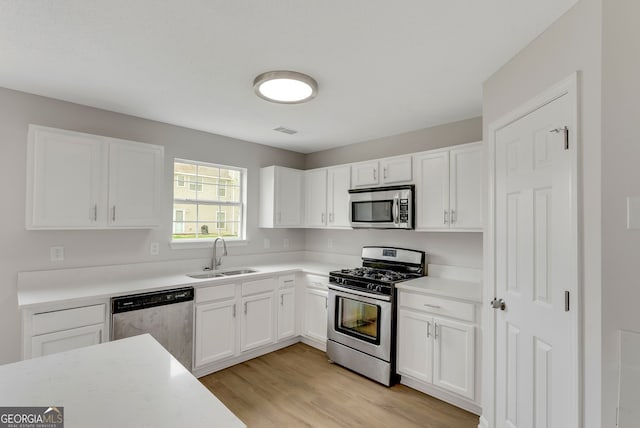 907 Brisley Cir, Hampton, GA 30228 - kitchen with appliances with stainless steel finishes, light wood-style floors, and white cabinetry