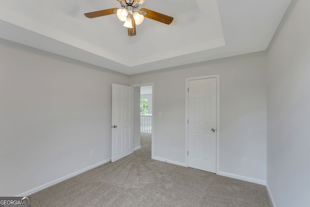907 Brisley Cir, Hampton, GA 30228 - unfurnished bedroom featuring carpet floors, a tray ceiling, and a ceiling fan