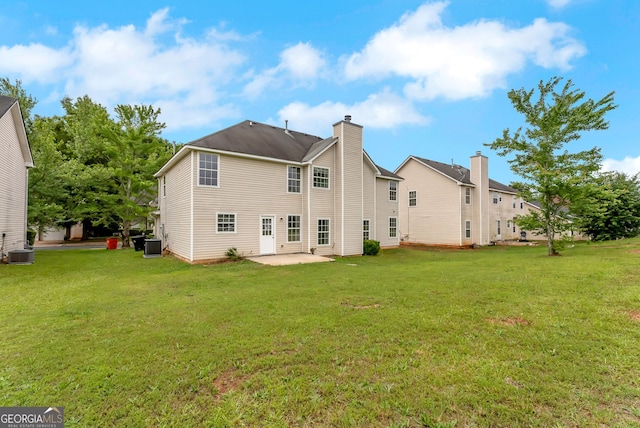 907 Brisley Cir, Hampton, GA 30228 - back of property featuring a patio, a lawn, and a chimney