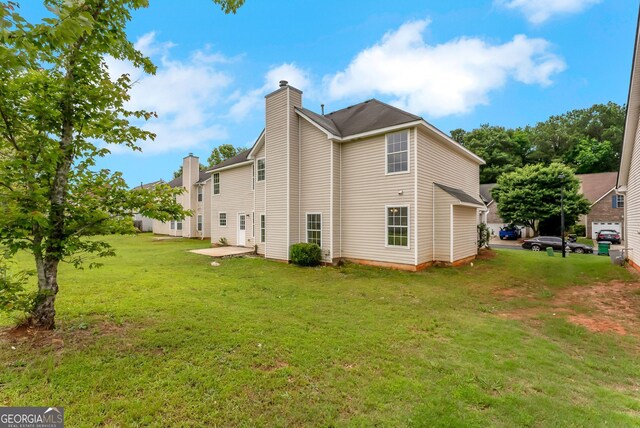 907 Brisley Cir, Hampton, GA 30228 - rear view of house featuring a chimney and a lawn
