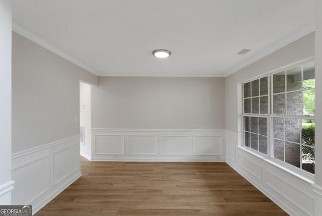 907 Brisley Cir, Hampton, GA 30228 - spare room with ornamental molding, a wainscoted wall, a decorative wall, and light wood-style flooring