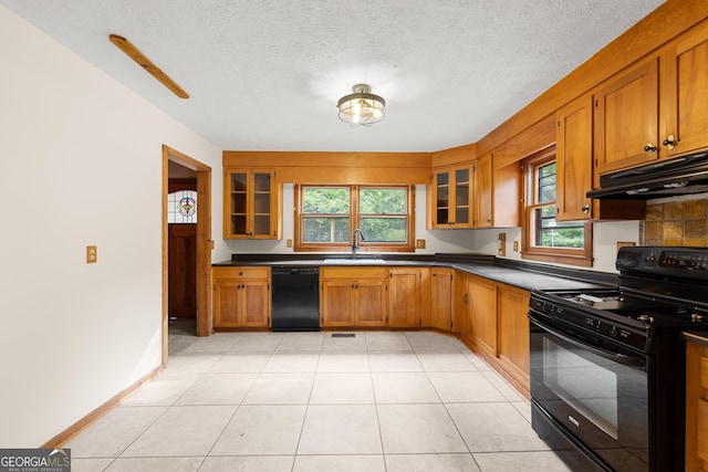 966 Wahoo Creek Rd, Murrayville, GA 30564 - kitchen with black appliances, under cabinet range hood, plenty of natural light, brown cabinets, and a textured ceiling