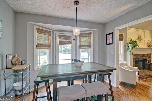 368 Lambeth Dr, Hiram, GA 30141 - dining space with plenty of natural light, a textured ceiling, wood finished floors, baseboards, and a brick fireplace
