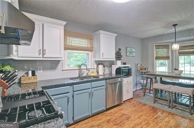 368 Lambeth Dr, Hiram, GA 30141 - kitchen featuring stainless steel appliances, range hood, a sink, white cabinetry, and a textured ceiling