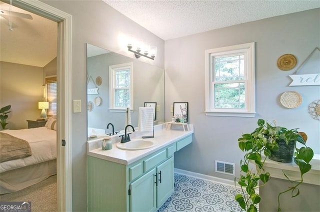 368 Lambeth Dr, Hiram, GA 30141 - ensuite bathroom featuring vanity, healthy amount of natural light, a textured ceiling, baseboards, and a ceiling fan