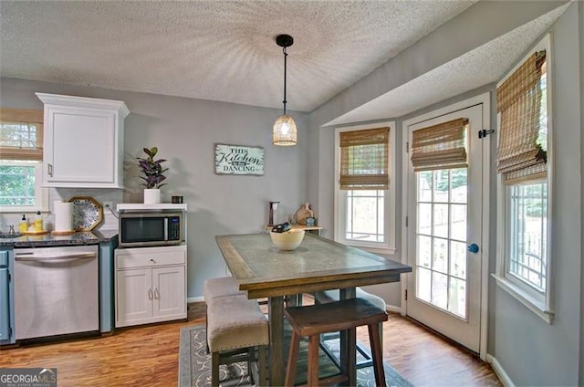 368 Lambeth Dr, Hiram, GA 30141 - dining room with light wood-style flooring, a textured ceiling, and baseboards