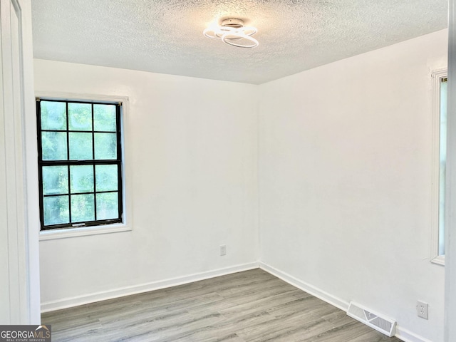 5 Red Fox Dr SW, Rome, GA 30165 - unfurnished room with wood finished floors, a textured ceiling, healthy amount of natural light, and baseboards