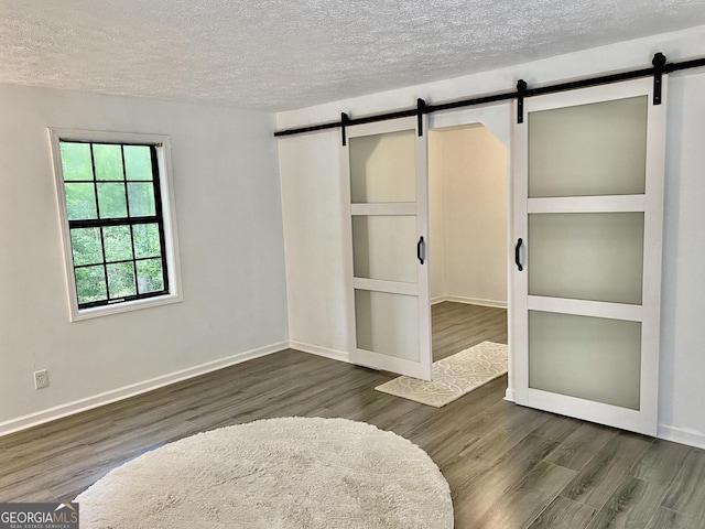 5 Red Fox Dr SW, Rome, GA 30165 - unfurnished room with a barn door, a textured ceiling, wood finished floors, and baseboards