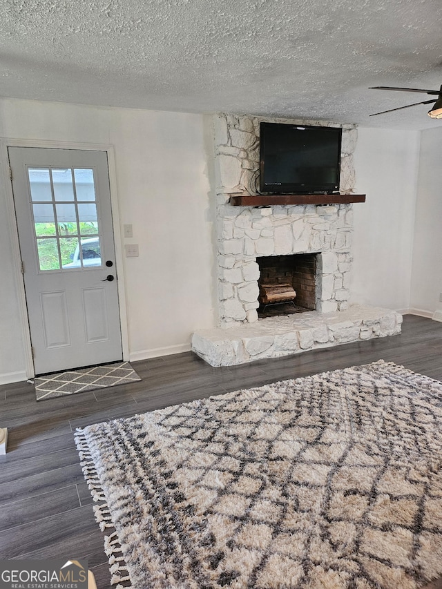 5 Red Fox Dr SW, Rome, GA 30165 - unfurnished living room featuring wood finished floors, baseboards, a textured ceiling, and a stone fireplace
