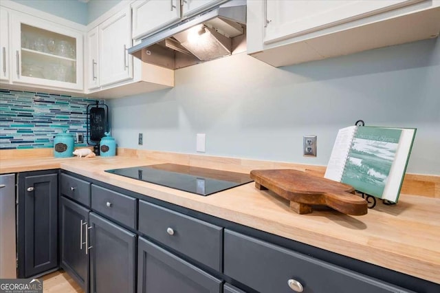 103 Ashley Marsh Dr, Brunswick, GA 31523 - kitchen with under cabinet range hood, black electric stovetop, white cabinetry, and backsplash
