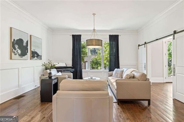 3834 Chamblee Dunwoody Rd, Atlanta, GA 30341 - living area featuring a barn door, a decorative wall, ornamental molding, and wood finished floors