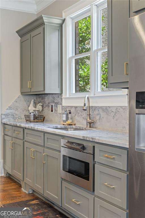 3834 Chamblee Dunwoody Rd, Atlanta, GA 30341 - kitchen with appliances with stainless steel finishes, gray cabinets, crown molding, and backsplash
