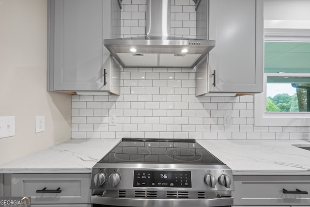 1180 Treadwell Bridge Rd, Statham, GA 30666 - kitchen with wall chimney exhaust hood, stainless steel range, gray cabinets, backsplash, and light stone counters