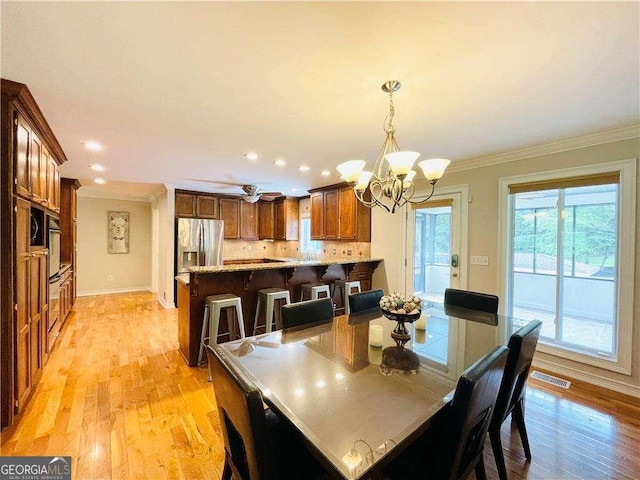 345 Etheridge Rd, Auburn, GA 30011 - dining area with a chandelier, crown molding, light wood-style flooring, and recessed lighting
