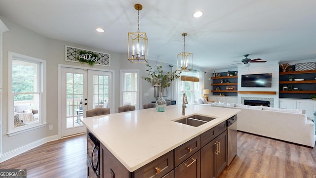 1346 Wind Chime Ct, Lawrenceville, GA 30045 - kitchen featuring a sink, light wood-style floors, a fireplace, black microwave, and decorative light fixtures