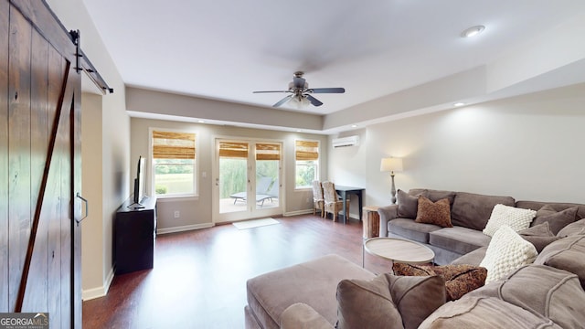 1346 Wind Chime Ct, Lawrenceville, GA 30045 - living room featuring a wall mounted AC, ceiling fan, a barn door, dark wood-type flooring, and baseboards